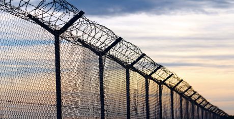 Silhouette of Barbed Wire fence against a Cloudy Sky